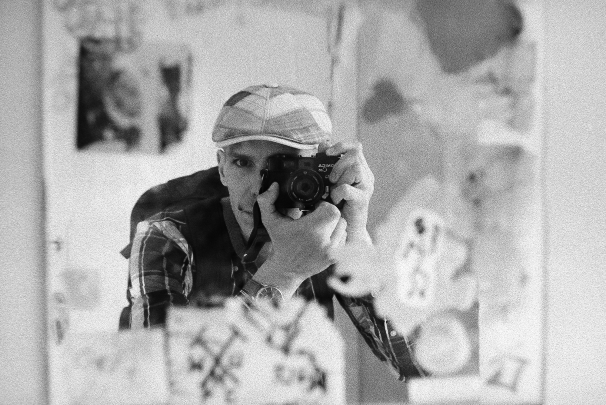 Self-portrait in a mirror, camera raised to the eye